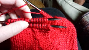 Pocket on front needle, sweater body on back needle. 